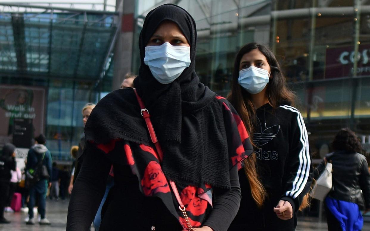 (FILES) In this file photo taken on August 22, 2020 Shoppers wearing protective face coverings walk past shops in Birmingham, central England. - Authorities in Britain's second city of Birmingham announced new coronavirus restrictions Friday, September 11, as the nation's reproduction rate, or R number, exceeded 1.0 for the first time since March. (Photo by JUSTIN TALLIS / AFP) (Photo by JUSTIN TALLIS/AFP via Getty Images) - JUSTIN TALLIS/AFP