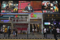 Pedestrians walk under a giant screen showing live telecast of Chinese President Xi Jinping, top center, at the closing session of the National People's Congress, in Hong Kong, Thursday, May 28, 2020. China’s ceremonial legislature on Thursday endorsed a national security law for Hong Kong that has strained relations with the United States and Britain. (AP Photo/Vincent Yu)