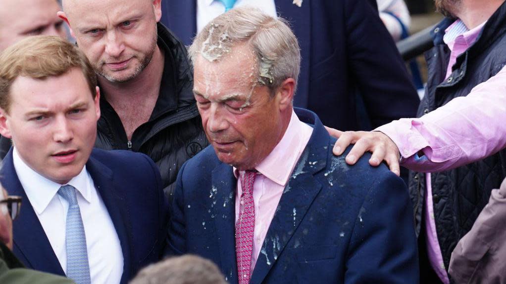 Nigel Farage with a drink spilt over his head and suit jacket