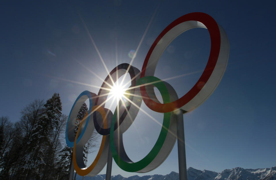 The sun shines through the Olympic rings at the Cross Country stadium at the 2014 Winter Olympics, Tuesday, Feb. 4, 2014, in Krasnaya Polyana, Russia. (AP Photo/Gregorio Borgia)