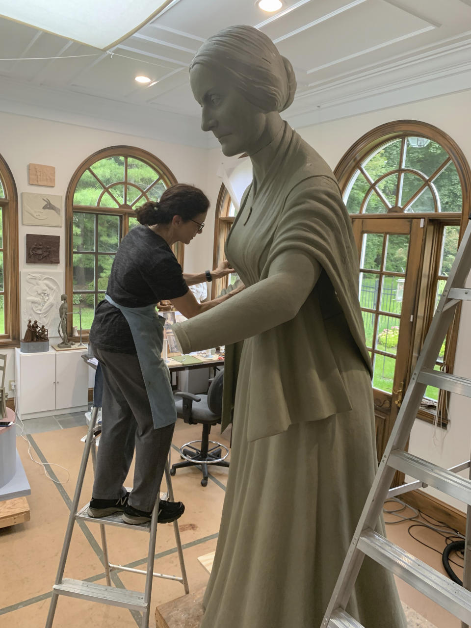 In this Sept. 10, 2019 photo provide by Michael Bergmann, artist Meredith Bergmann works on a sculpture of Susan B. Anthony at her studio in Ridgefield, Conn. A New York City commission voted Monday, Oct. 21 to erect a tribute to three civil rights pioneers: Susan B. Anthony, Elizabeth Cady Stanton and Sojourner Truth. Bergmann's work is to be dedicated next August in Central Park, marking the 100th anniversary of women's suffrage in the United States. (Michael Bergmann via AP)