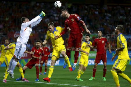 Spain's Sergio Ramos jumps to head the ball (C) next to Ukraine's Olexandr Kucher (2nd L) as goalkeeper Andriy Pyatov clears (L) during their Euro 2016 qualifier soccer match at Ramon Sanchez Pizjuan stadium in Seville, March 27, 2015. REUTERS/Marcelo del Pozo