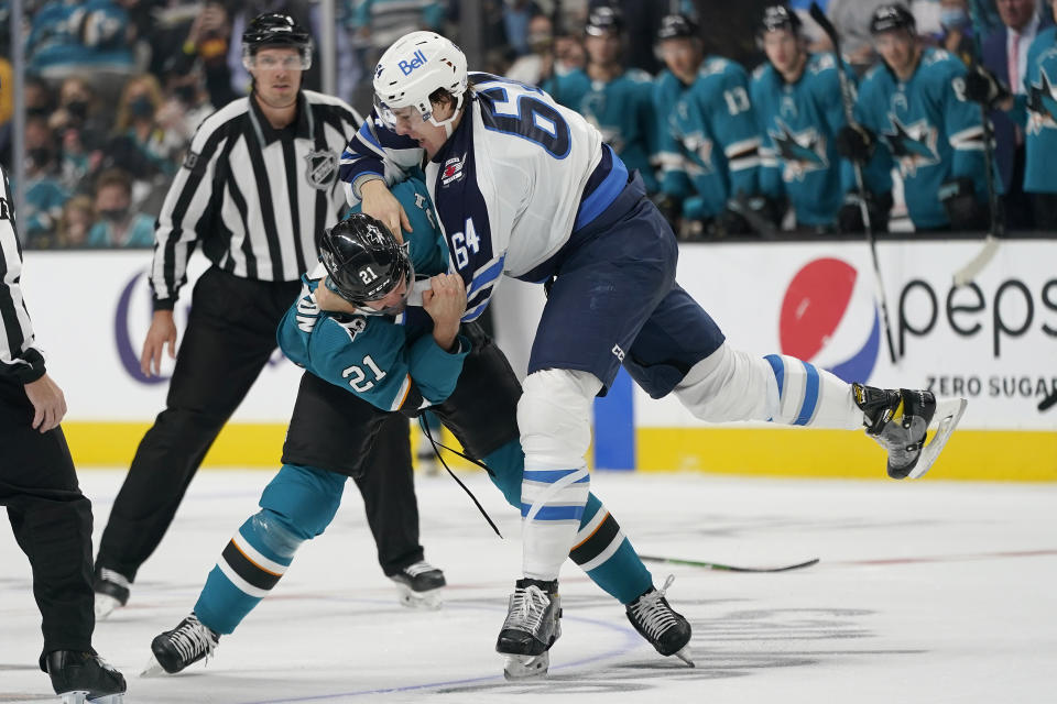 San Jose Sharks defenseman Jacob Middleton (21) fights Winnipeg Jets defenseman Logan Stanley (64) during the second period of an NHL hockey game in San Jose, Calif., Saturday, Oct. 16, 2021. (AP Photo/Jeff Chiu)
