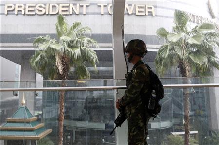 A soldier stands guard at an elevated walkway of a shopping district in central Bangkok May 25, 2014. REUTERS/Erik De Castro