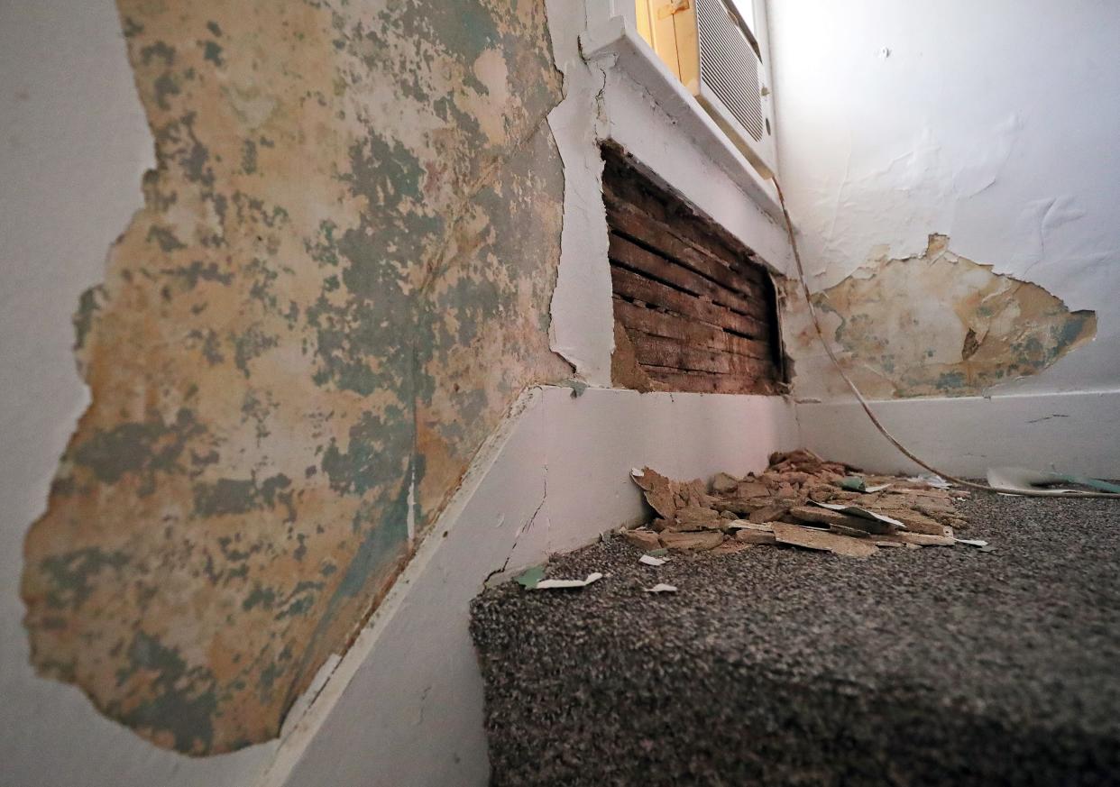 The paint and plaster around the window at the top of this Akron tenant’s staircase is chipped off and busted up.