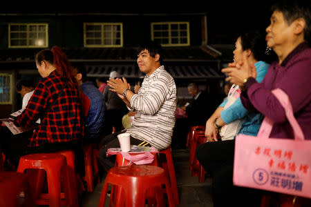 Chen Hong-zhi, 26, who suffers from short-term memory loss, claps during an election campaign rally, in the Beipu Old Street area, in Hsinchu, Taiwan, November 6, 2018. REUTERS/Tyrone Siu