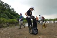 Climate activist Elise Hon, 11, picks up trash at San Tau Beach during a climate strike and a beach clean-up on Lantau island in Hong Kong