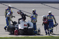 FILE - Josef Newgarden, third from left, climbs out of his car after hitting a wall during the IndyCar Series auto race, Sunday, July 24, 2022, at Iowa Speedway in Newton, Iowa. Newgarden was scheduled to be evaluated Thursday, July 28, 2022, to determine if he can race in this weekend's shared event with NASCAR at Indianapolis Motor Speedway. Newgarden collapsed and hit his head at Iowa Speedway following a hard crash. (AP Photo/Charlie Neibergall, File)