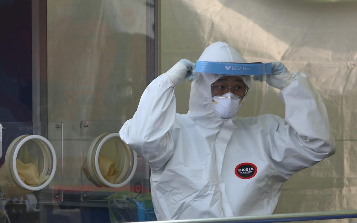 A health worker in protective gear prepares to work at a makeshift clinic in Seoul - KIM CHUL-SOO/EPA-EFE/Shutterstock 