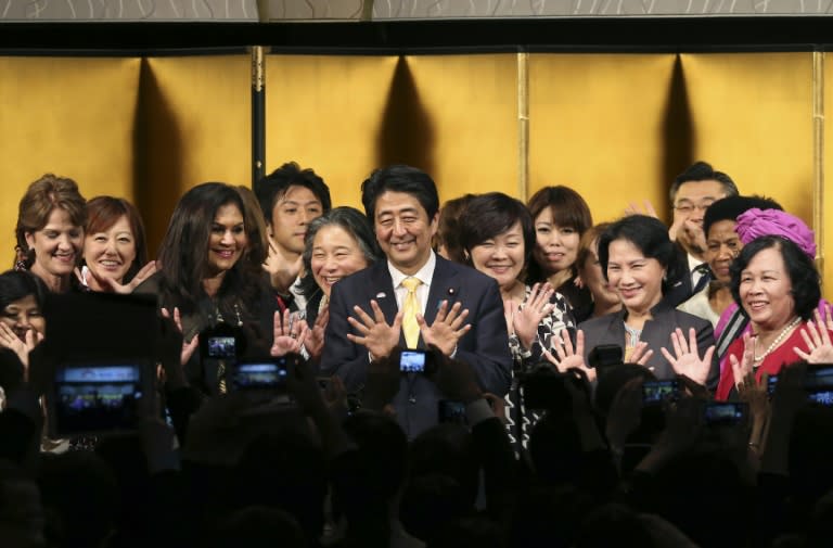 Japanese Prime Shinzo Abe (C) poses for a photo with participants during a reception of the World Assembly for Women in Tokyo on August 28, 2015