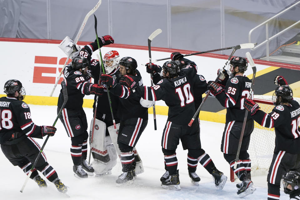 St. Cloud State goaltender David Hrenak, third from left, celebrates with teammates after a 5-4 win over Minnesota State in an NCAA men's Frozen Four hockey semifinal in Pittsburgh, Thursday, April 8, 2021. (AP Photo/Keith Srakocic)