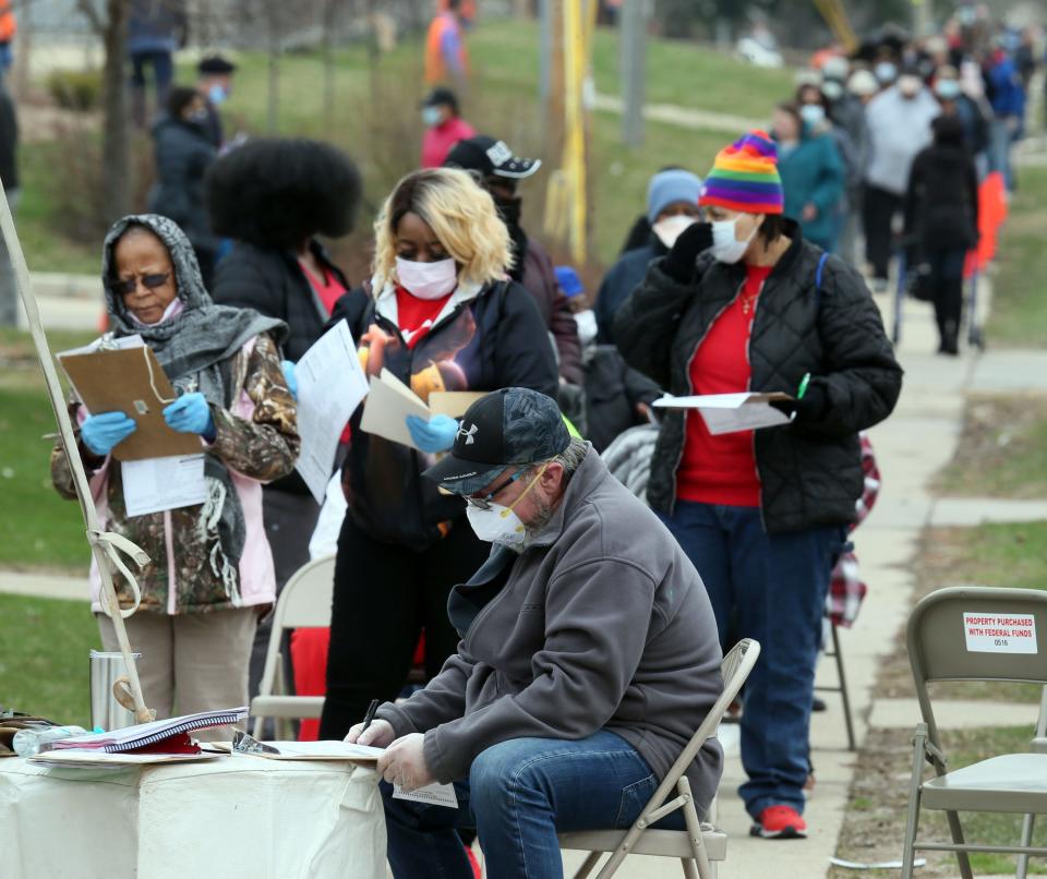 People stand and sit while voting April 7, 2020, in an area designated for those needed additional assistance for voting at Marshall High School in Wisconsin. Gov. Tony Evers sought to shut down today's election in a historic move because of the coronavirus pandemic that was rejected by the Wisconsin Supreme Court. Despite that decision a large crowd turned out at Marshall to wait for some over an hour in long lines.