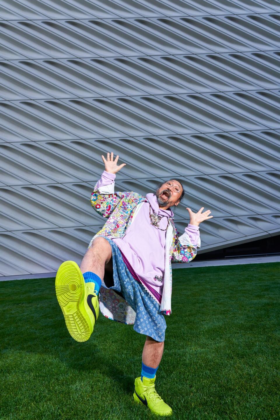 A man poses with his leg up on a lawn.