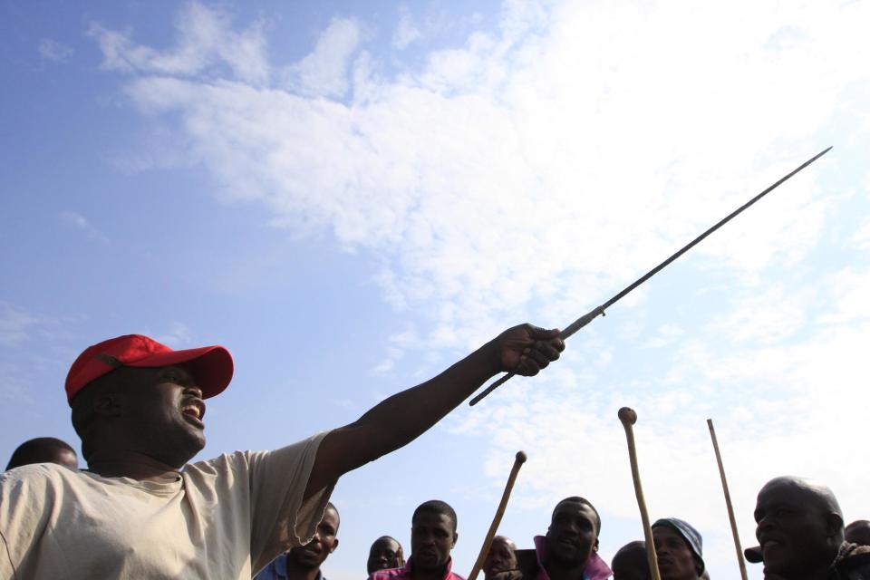 A man leads striking miners in a dance near Rustenburg, South Africa, on Wednesday, Nov. 14, 2012. Workers discussed a possible deal with Anglo American Platinum, or Amplats, on Wednesday as their weeks-long strike continued. Amplats is the world's top producer of platinum. (AP Photo/Jon Gambrell)