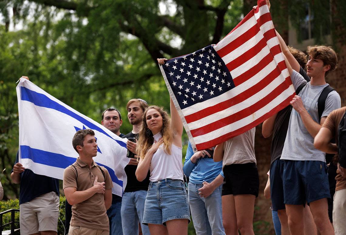 People sing “The Star-Spangled Banner” while holding Israeli and American flags on the steps of South Building at UNC-Chapel Hill on Tuesday, April 30, 2024. UNC-Chapel Hill police charged 36 members of a pro-Palestinian “Gaza solidarity encampment” Tuesday morning after warning the group to remove its tents from campus or face possible arrest, suspension or expulsion from the university.