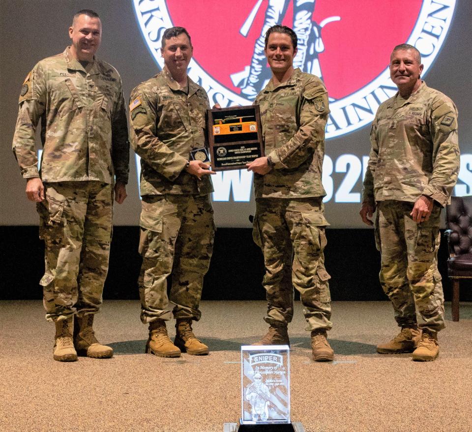 Col. Kevin Cox, National Guard Marksmanship Training Center commander, and Command Sgt.
Maj. Paul Winkle present champions Sgt. 1st Class Mark Williams and Staff Sgt. B.J. Underkofler with the 32nd David R. Logan Sniper Team Trophy.

Military sniper teams competed at the Fort Chaffee Joint Maneuver Training Center December 2-9, 2022.