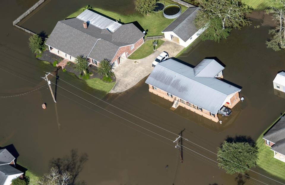 FILE - In this Oct. 10, 2020 file photo, houses surrounded by flood waters are seen in the aftermath of Hurricane Delta Saturday in Welsh, La. Hurricane Delta, which made landfall about 11 miles from where the devastating Hurricane Laura hit a little more than a month earlier, cost $2.9 billion in the United States and was linked to six deaths in the U.S. and Mexico, according to a report from the National Hurricane Center. (Bill Feig/The Advocate via AP, Pool, File)