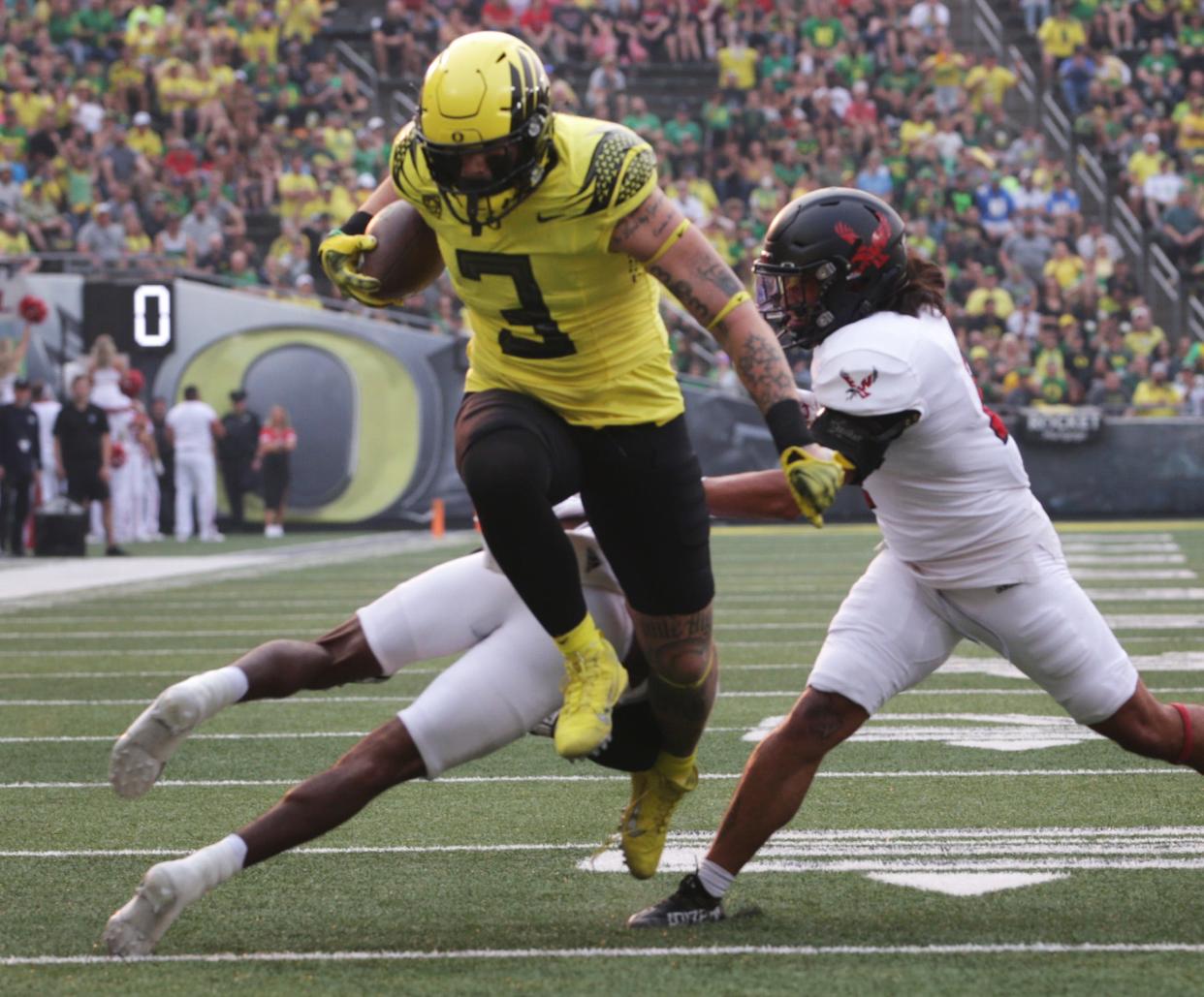 Oregon's Terrance Ferguson, center, breaks a tackle on his way to a first quarter touchdown against Eastern Washington in September 2022.