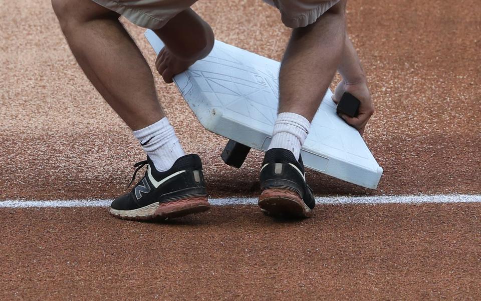 A grounds crewman installed third base before the Louisville Bats hosted the St. Paul Saints during their game at Slugger Field in Louisville, Ky. on June 2, 2021.