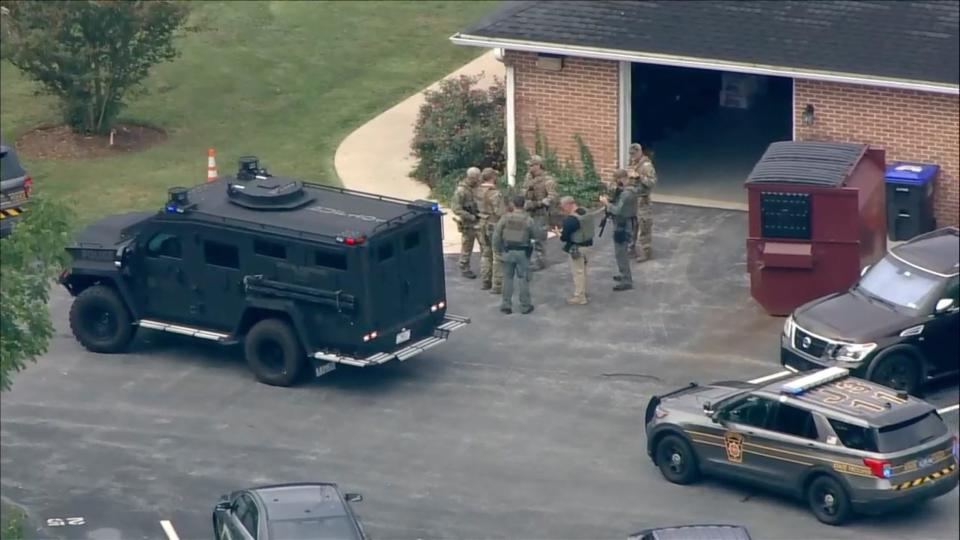 Law enforcement agents stand by an armored vehicle with Danelo Souza Cavalcante inside at the Pennsylvania State Police barracks in Avondale, Pa., on Wednesday, Sept. 13, 2023.