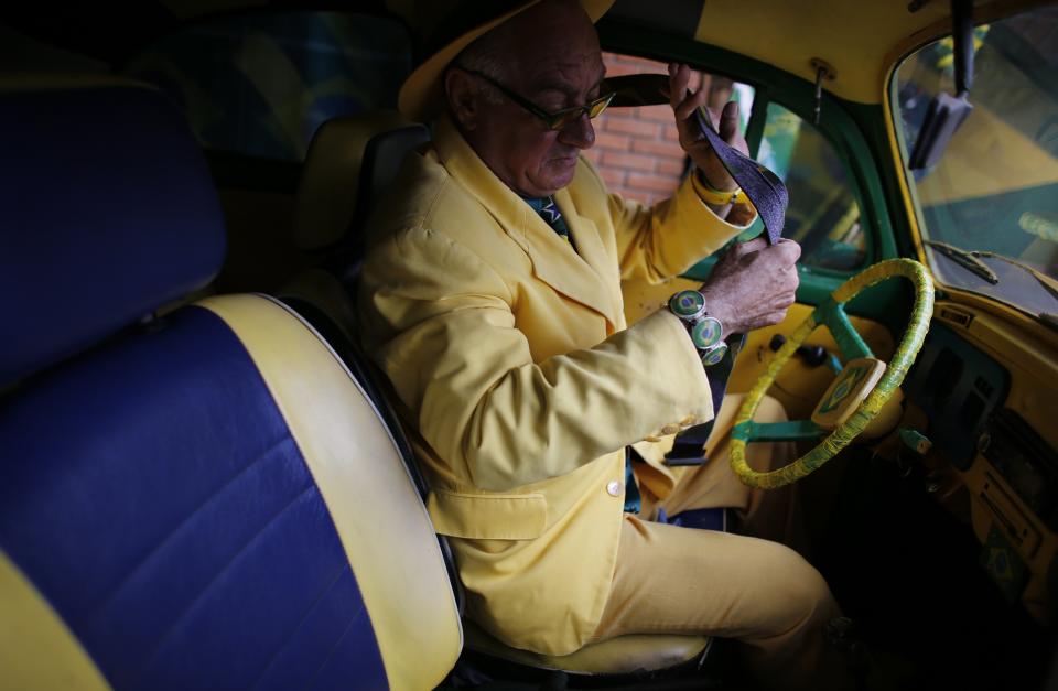 Brazilian attorney, Nelson Paviotti, gets into one of his two Volkswagen Beetles painted with the colors of the national flag in Campinas