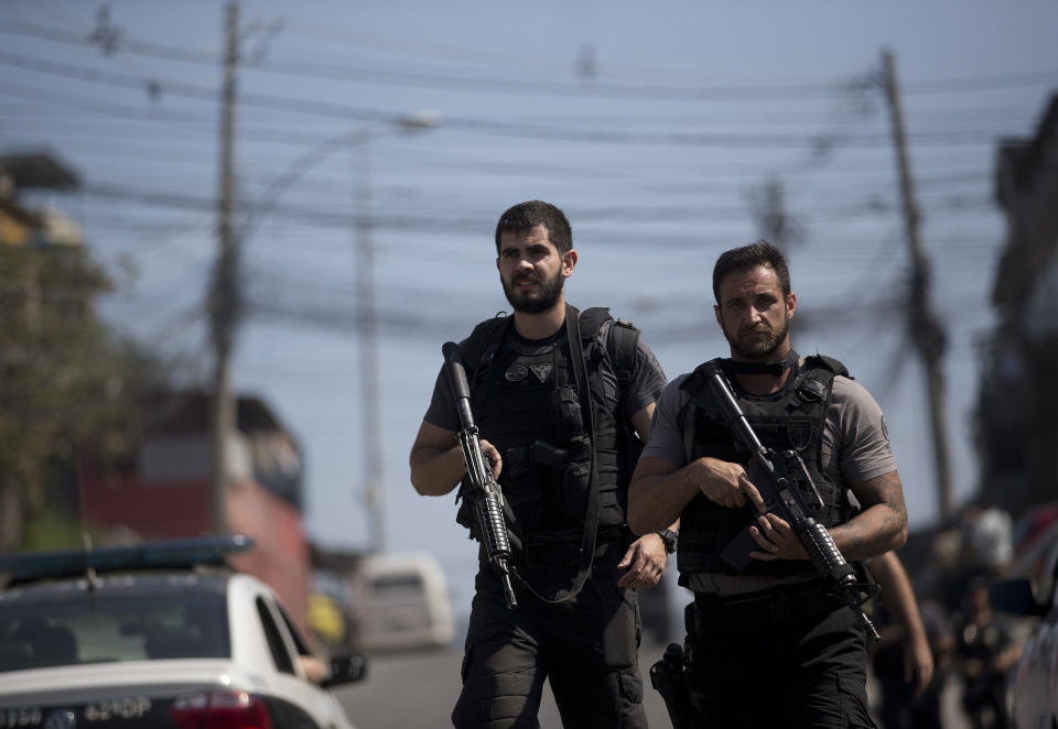 Police officers patrol the Complexo de Alemao slum during an operation in Rio de Janeiro, Brazil, Monday, Aug. 20, 2018. At least 11 people have been killed during shootouts involving military personnel and police in Rio on Monday. Since February, the military has been in charge of security in the state of Rio de Janeiro, which is struggling to curb a spike in violence. (AP Photo/Silvia Izquierdo)