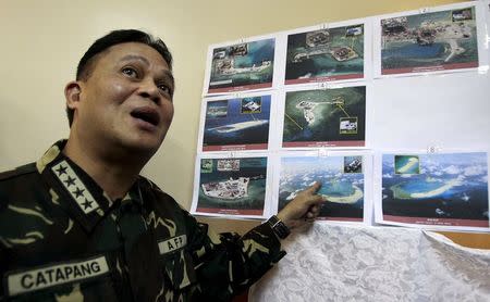 Armed Forces of the Philippines (AFP) Chief of Staff Gregorio Pio Catapang shows some images of the structures being built by China at the disputed islands during a news conference at the AFP headquarters in Manila April 20, 2015. REUTERS/Romeo Ranoco