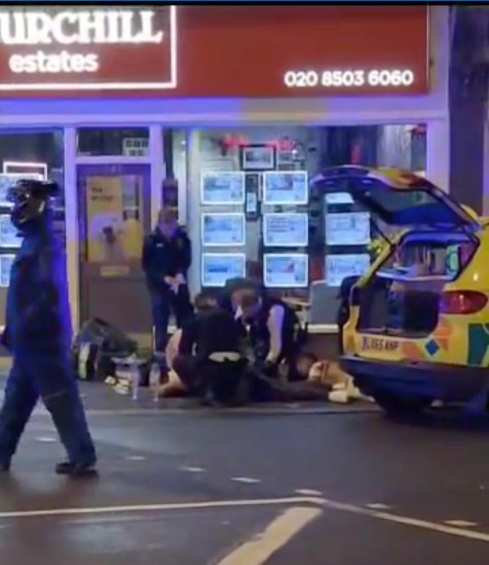 Officers attend to the injured men in Waltham Forest on Sunday (Supplied)