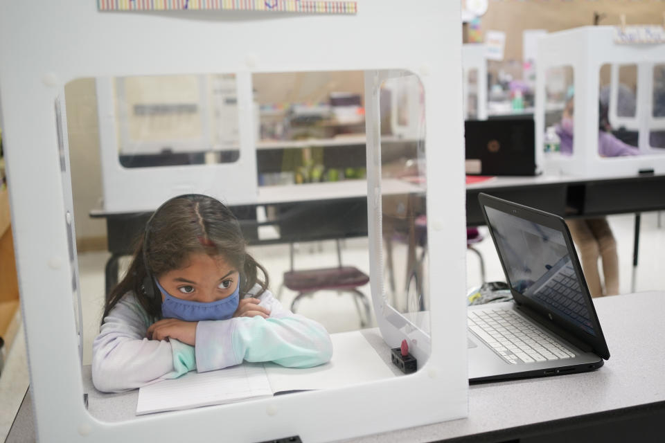 Second grader Londyn Vargas does her school work at Christa McAuliffe School in Jersey City, N.J., Thursday, April 29, 2021. Kindergarten through third grade students are returning to their school buildings in Jersey City for their first time in over a year. New Jersey's two largest cities have begun making their return to classrooms in person after working remotely because of the COVID-19 outbreak. Students in Jersey City began returning to school today, just days after Newark officials said they were expanding in-person instruction to four days a week, up from two. (AP Photo/Seth Wenig)