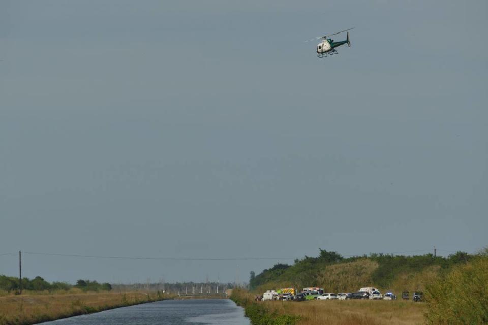 A Miami-Dade Fire Rescue helicopter searches a Southwest Miami-Dade canal after a helicopter crashed on Wednesday, Dec. 27, 2023.