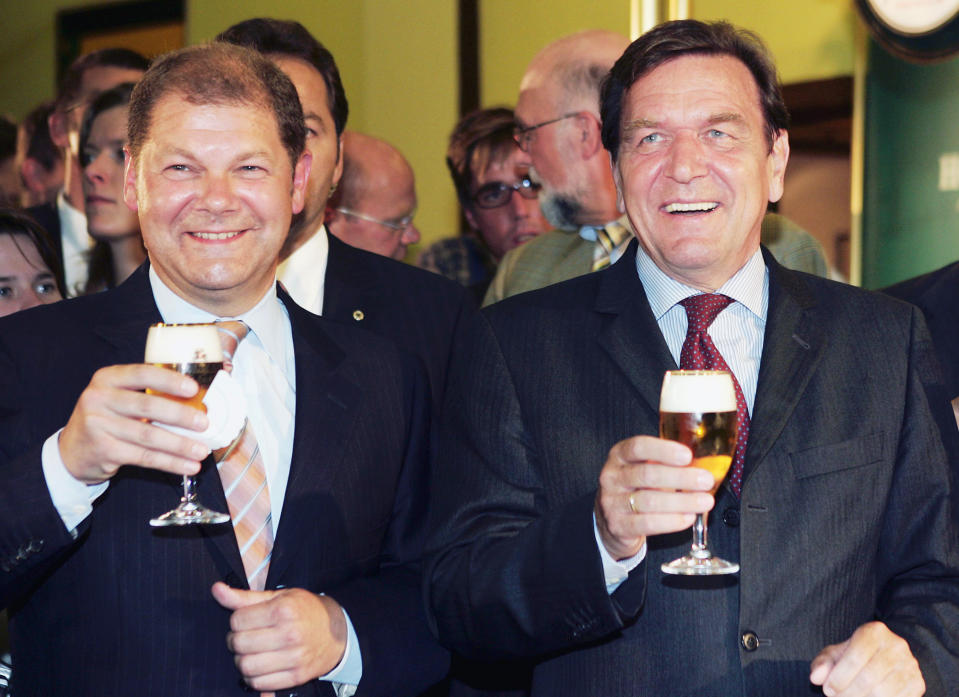File-File Photo shows German Chancellor Gerhard Schroeder, right, drinking a glass of beer with Social Democratic member of German parliament Olaf Scholz during their visit to the Holsten brewery in Hamburg, northern Germany on Wednesday, Aug. 3, 2005. German Chancellor Olaf Scholz is flying to Washington this week on a mission to reassure Americans that his country stands alongside the United States and other NATO partners in opposing any Russian aggression against Ukraine.(AP Photo/Fabian Bimmer, file)