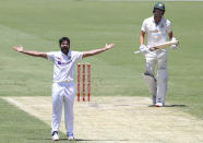 India's Shardul Thakur, left, appeals successfully for the wicket of Australia's Pat Cummins, right, during play on day two of the fourth cricket test between India and Australia at the Gabba, Brisbane, Australia, Saturday, Jan. 16, 2021. (AP Photo/Tertius Pickard)