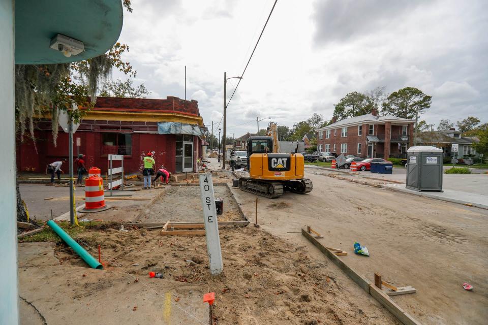 Workers make improvements to the crosswalks and sidewalks along Waters Avenue.