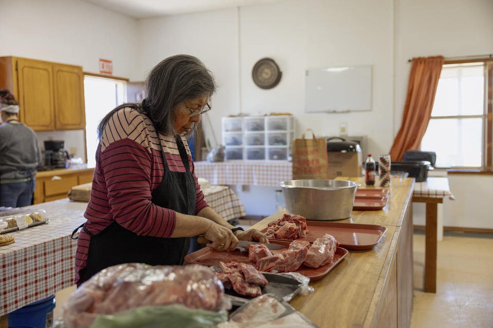 Members of the Springfield United Methodist Church in Okemah, Okla., prepare pork for cooking on April 5, 2024. Fried pork is an important dish at wild onion dinners in Oklahoma. The dinners are an annual tradition among tribal nations in the state originally from the southeastern U.S. (AP Photo/Brittany Bendabout)