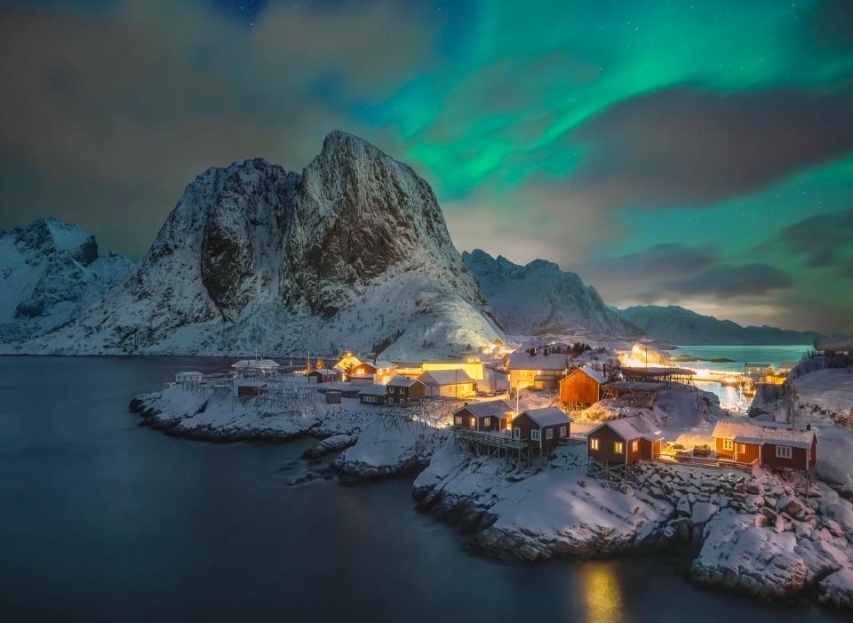 a town by the water with mountains in the background