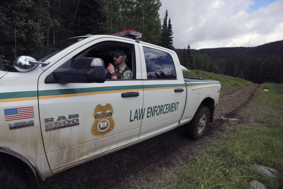 A Forest Service officer patrols the periphery of the Rainbow Gathering on Friday, July 2, 2021, in the Carson National Forest, outside of Taos, N.M. More than 2,000 people have made the trek into the mountains of northern New Mexico as part of an annual counterculture gathering of the so-called Rainbow Family. While past congregations on national forest lands elsewhere have drawn as many as 20,000 people, this year’s festival appears to be more reserved. Members (AP Photo/Cedar Attanasio)