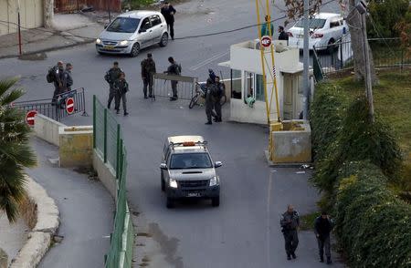 Israeli border policemen stand guard near the scene where a Palestinian man stabbed and critically wounded an Israeli before being shot dead by Israeli forces, in the West Bank city of Hebron December 7, 2015. REUTERS/Mussa Qawasma