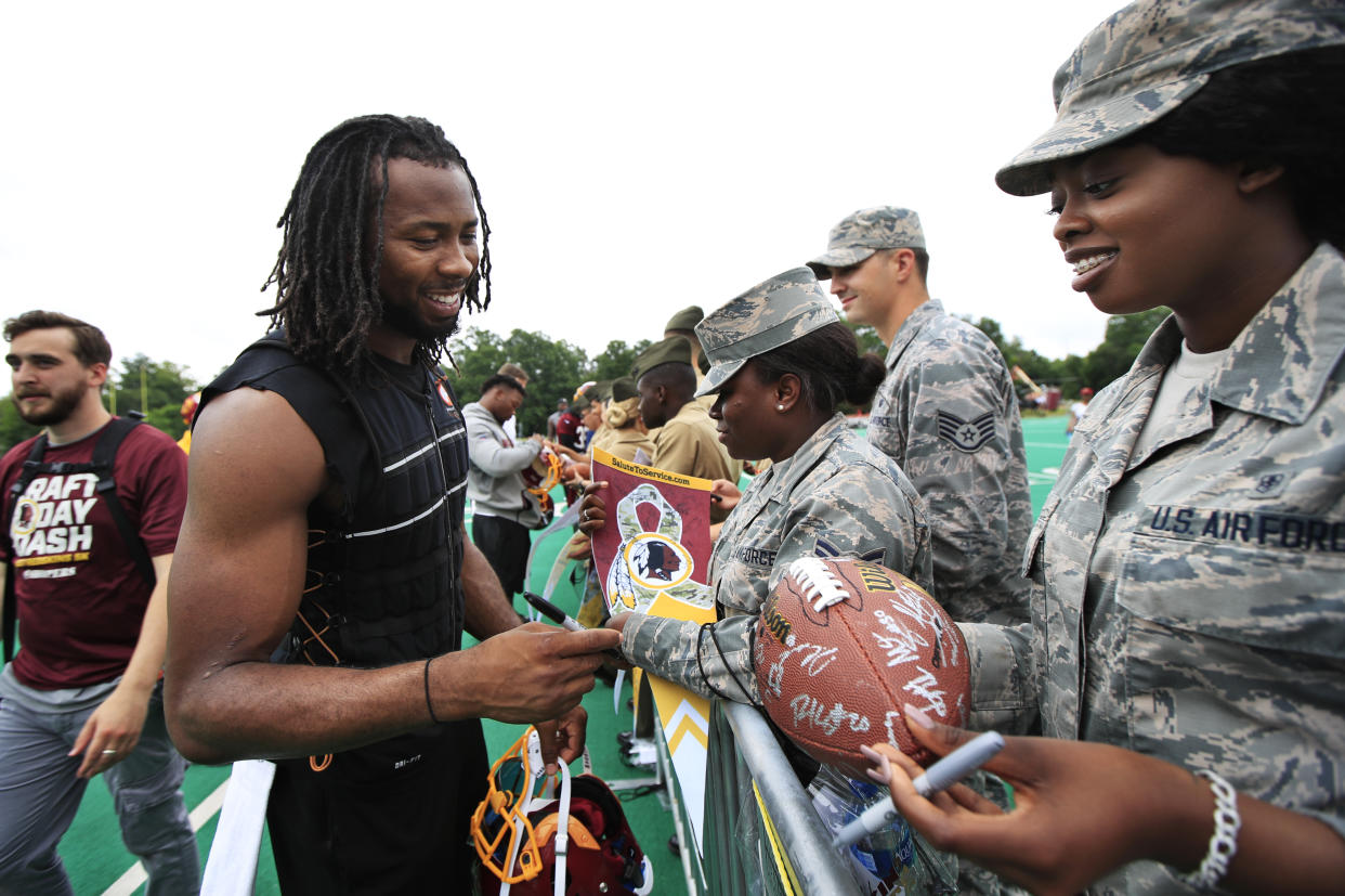 Redskins cornerback Josh Norman, left, signs autographs for military members following a practice. (AP)