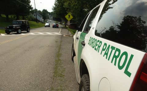 A US Border Patrol waits a few meters away from the United States-Canada border - Credit: Adam Nadel