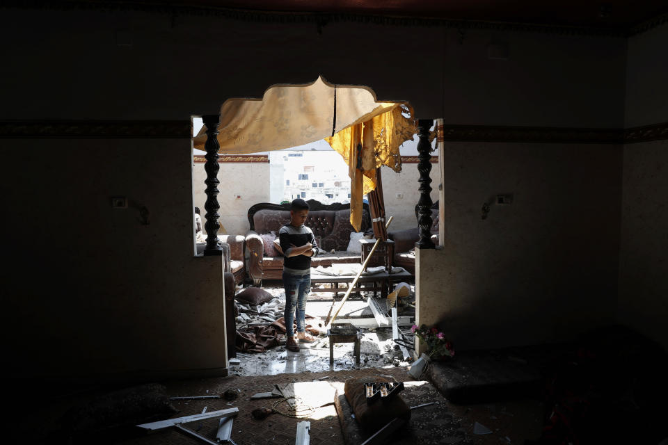 A child looks at the damaged room of his family apartment after by Israeli airstrikes near a residential building, in Beit Lahiya, Gaza Strip, Thursday, May 20, 2021. (AP Photo/Adel Hana)