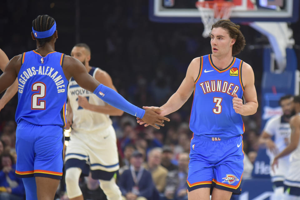 Oklahoma City Thunder guard Josh Giddey (3) celebrates with guard Shai Gilgeous-Alexander (2) during the first half of the team's NBA basketball game against the Minnesota Timberwolves, Tuesday, Dec. 26, 2023, in Oklahoma City. (AP Photo/Kyle Phillips)