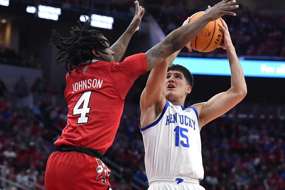 Kentucky guard Reed Sheppard (15) looks to shoot over Louisville guard Ty-Laur Johnson (4) during the first half of an NCAA college basketball game in Louisville, Ky., Thursday, Dec. 21, 2023. (AP Photo/Timothy D. Easley)