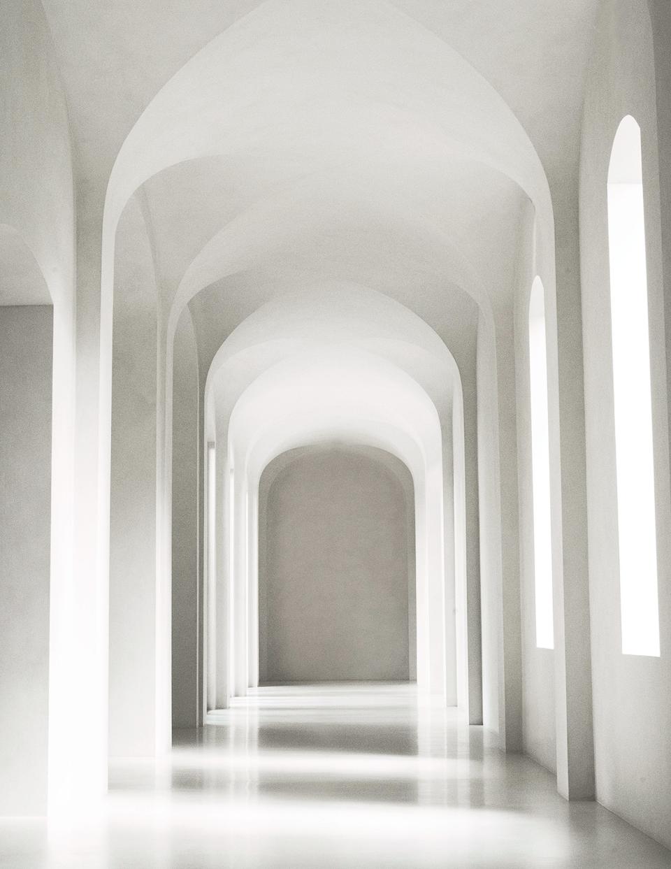 A soaring hallway is swathed in off-white plaster.