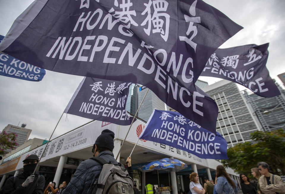 Protesters wave flags that say "Hong Kong Independence" during a rally in Hong Kong, Sunday, Dec. 15, 2019. Hong Kong police said on Saturday that they have arrested three men for testing homemade explosives they suspect were intended for use during protests. (AP Photo/Mark Schiefelbein)