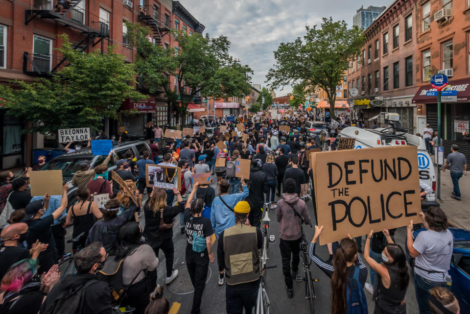 A participant holding a Defund The Police sign at the protest. Thousands of protesters filled the streets of Brooklyn in a massive march to demand justice for George Floyd, killed by Officer Derek Chauvin and to make a loud call for the defunding of the police force. (Erik McGregor/LightRocket via Getty Images)