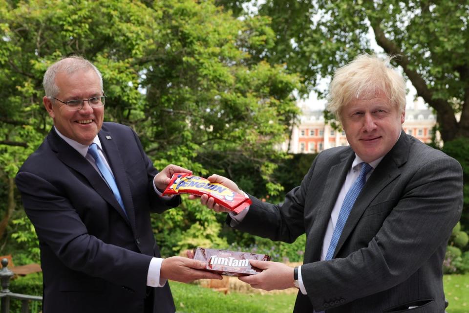 Former prime ministers of Australia and the UK, Scott Morrison and Boris Johnson, pose with Penguins and Tim Tams in 2021 (Andrew Parsons / No10 Downing Street)