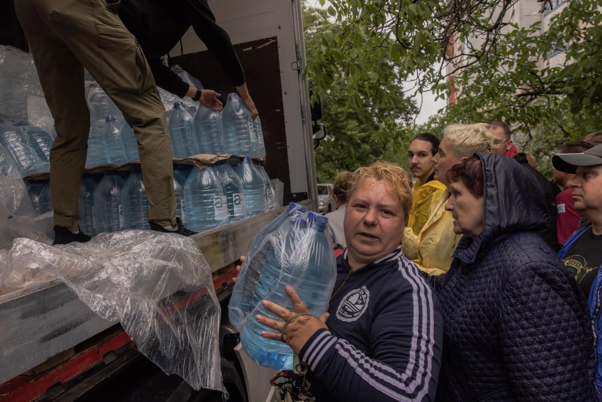 A woman clutches two bottles of water being handed out in humanitarian aid in Kherson on Sunday (Getty Images)