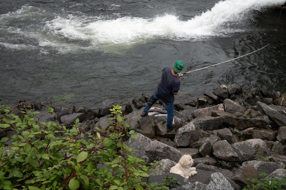 Cal Broncheau (Nez Perce Tribe member) and his dog, Chubby, fish for salmon and steelhead on the Clearwater River on Sept. 30, 2023, at the Dworshak National Fish Hatchery, west of Orofino, Idaho.