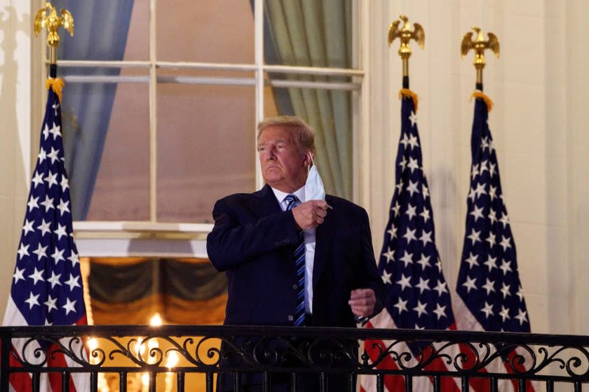 President Donald Trump remove his mask on the balcony of the White House