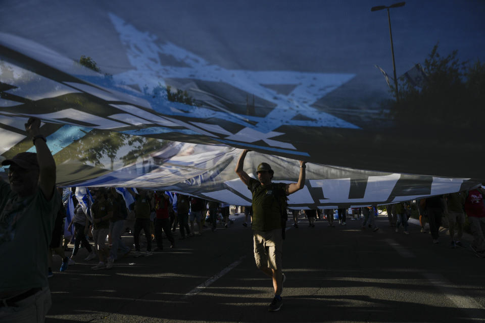 People take part in a protest against Israeli Prime Minister Benjamin Netanyahu's government, demanding new elections and the release of the hostages held in the Gaza Strip by the Hamas militant group, outside of the Knesset, Israel's parliament, in Jerusalem, Monday, June 17, 2024. (AP Photo/Ohad Zwigenberg)